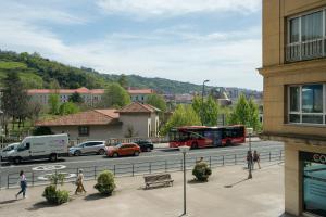 a red bus driving down a street in a city at Zubia apartment by People Rentals in Bilbao