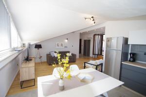 a kitchen and living room with a white table and a room at Apartman Luci in Valbandon