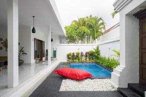 - une cour avec une piscine et un oreiller rouge dans l'établissement Casa Jinah 1 I Simply Modern Twin Villas (2BR) with Private Pool, à Seminyak