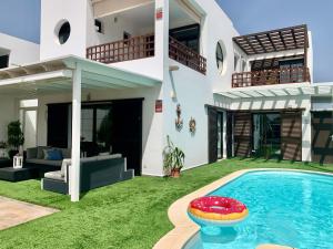 a house with a swimming pool in the yard at Villa Santa Maria in Costa Teguise