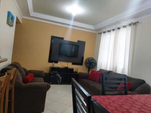 a living room with two couches and a flat screen tv at Edificio Fernanda in Porto Belo