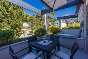 einen Tisch und Stühle auf einem Balkon mit Aussicht in der Unterkunft Apartment Vito in Njivice