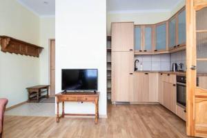 cocina con TV y mesa en una habitación en HOT RIGA ERNESTINES 7-2 Enjoy the feel of home and history!, en Riga