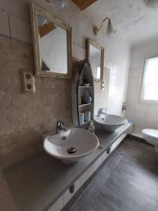 a bathroom with two sinks and two mirrors at Ferienwohnung Dölzig in Schkeuditz
