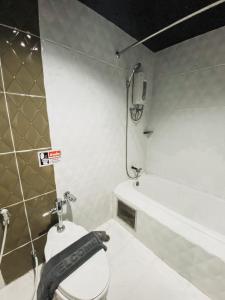 a bathroom with a toilet and a bath tub at Garden View Betong Hotel in Betong