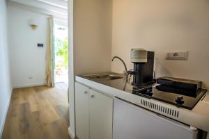 a kitchen with a sink and a stove top oven at Maison d'Orange - La Pinede in Saint-Tropez