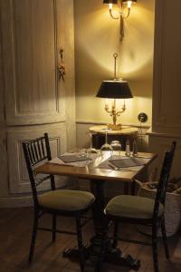 uma mesa de jantar com duas cadeiras e um candeeiro em Hôtel de Colbert em Aubusson