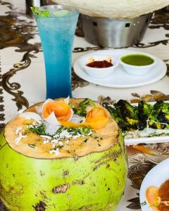 a table with a plate of food and a drink at Majestic Hotel in Nashik
