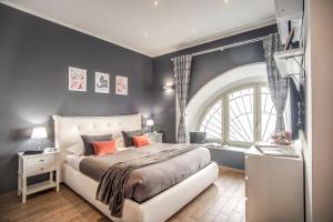 sypialnia z dużym łóżkiem i dużym oknem w obiekcie Colosseum Royal Apartment w Rzymie