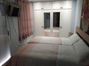 een kleine slaapkamer met een bed en een televisie bij Maria Guerrero Cala Pinchosos in Cabo de Palos
