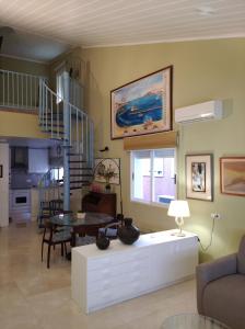 ein Wohnzimmer mit einem Tisch und einer Wendeltreppe in der Unterkunft Maria Guerrero Cala el Pato in Cabo de Palos