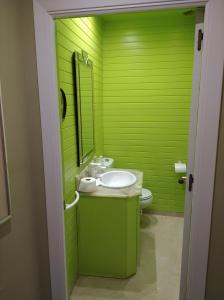 a green bathroom with a sink and a toilet at Maria Guerrero Cala el Pato in Cabo de Palos