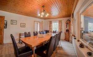 comedor con mesa de madera y sillas en Ferienhaus Schlei, en Rabenkirchen-Faulück