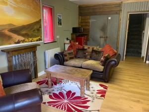 a living room with a couch and a table at Hay View Lodges - Barn End in Hay-on-Wye