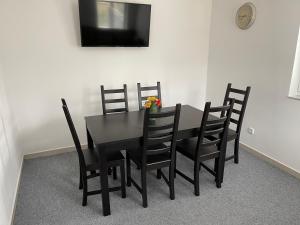 a black dining room table with black chairs and a television at Chata Marine in Bítov