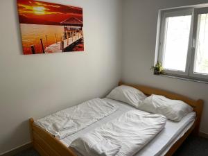 a bed in a bedroom with a picture on the wall at Chata Marine in Bítov