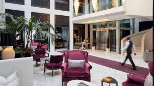 a person walking in a lobby with chairs and tables at Queen Victoria Hotel by NEWMARK in Cape Town +146 photos