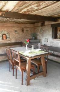 einen Holztisch mit Stühlen und eine Vase mit einer Blume darauf in der Unterkunft Casa Rural El Cotu en Cangas de Onís in Cangas de Onís