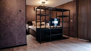 Habitación con cama y estantería de libros negros en Hotel Biesbosch, en Drimmelen