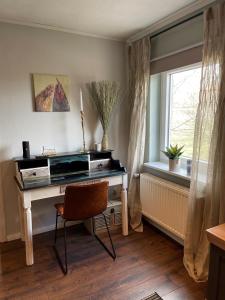 a desk in a room with a window and a chair at Heidezeit 5 in Neuenkirchen