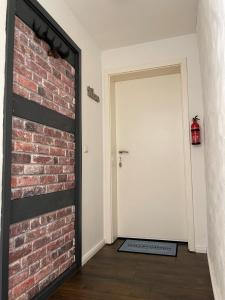 a brick wall next to a white door at Heidezeit 5 in Neuenkirchen