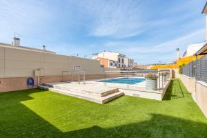 Un patio trasero con piscina y césped en CONFORT APARTMENT, en Roses 4 fotos más