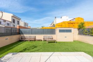 un patio trasero con dos bancos y un patio de césped en CONFORT APARTMENT, en Roses
