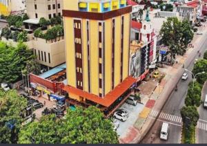 ナゴヤにあるSOVRANO HOTEL BATAM fka PARKSIDE SOVRANO HOTELの通路脇の大きな黄色い建物