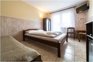 1 dormitorio con cama, escritorio y ventana en Willa Marlin, en Pobierowo