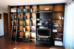 a book shelf with a television in a room at Casa vacanze Valle d'Aosta - Maison Lugon in Aosta