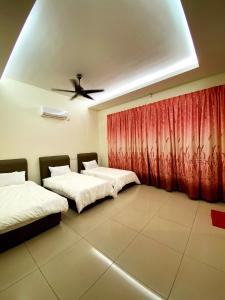two beds in a room with a ceiling fan at 40PAX 7BR Villa with Kids Swimming pool, KTV, Pool Table n BBQ near SPICE Arena Penang 9800 SQFT in Bayan Lepas +20 photos