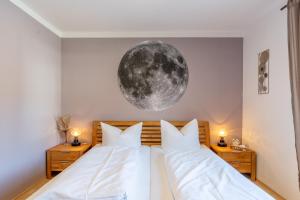 a bedroom with two beds with a moon mural on the wall at Breitenberg in Bad Hindelang