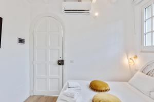 a white room with a bed and a white door at Maison d'Orange - La Pinede in Saint-Tropez