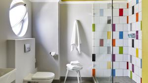 a bathroom with a toilet and a glass shower at La Splendida Hotel by NEWMARK in Cape Town +37 photos