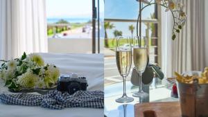 a table with a camera and two glasses of champagne at La Splendida Hotel by NEWMARK in Cape Town
