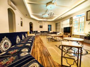 a living room with a couch and tables and a television at Sara Farm in Abu Dhabi