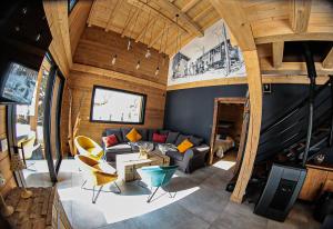 a living room with a couch and a tv at Le Chalet Margaux La Bresse in La Bresse