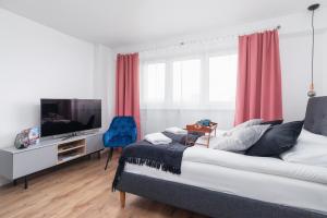 1 dormitorio con 1 cama y TV de pantalla plana en Apartments Kraków Czarnowiejska by Renters, en Cracovia