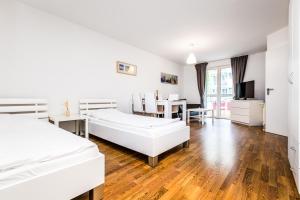 Habitación blanca con 2 camas y zona de comedor. en City Apartment Köln, en Colonia