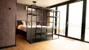 a bedroom with a black book shelf next to a bed at Hotel Biesbosch in Drimmelen