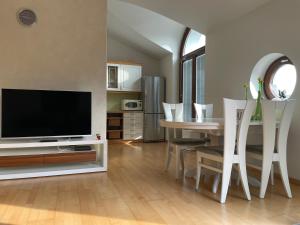 a living room with a television and a table with chairs at Apartment Olympus - one bedroom apartment in Portorož