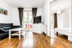 a living room with a couch and a tv and a table at City Apartment Köln in Cologne