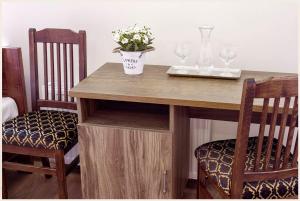 a table with two chairs and a vase with flowers on it at Mandarin Restoran & Hostel in Haapsalu
