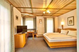 een hotelkamer met een bed en een televisie bij Landgasthof Schmalhofer in Tittling