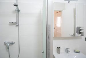 ein Bad mit einer Dusche, einem Waschbecken und einem Spiegel in der Unterkunft Brand New Studio with Garage - Close to the Beach in Acquarica del Capo