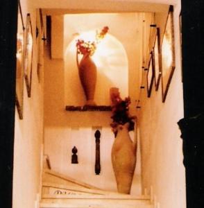a shelf with two vases and other items on a wall at la maison de l'architecte in Hammamet