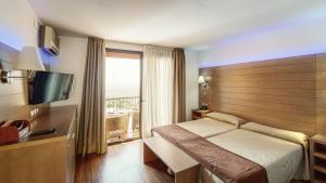 Hotel Sierra de Cazorla & SPA 3* في كازورلا: غرفه فندقيه بسرير ونافذه