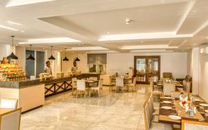 een restaurant met tafels en stoelen en een chef-kok in de keuken bij TRIBHAV Corbett Bliss-Jim Corbett in Rāmnagar