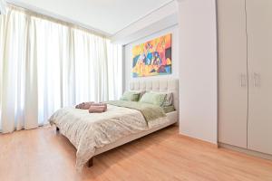 1 dormitorio con 1 cama y una pintura en la pared en Modern flat in the heart of Port of Piraeus (D2), en Pireo