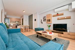 a living room with a blue couch and a table at Modern flat in the heart of Port of Piraeus (D2) in Piraeus